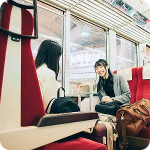箱根へ向かう電車内で会話を楽しむ女性2人