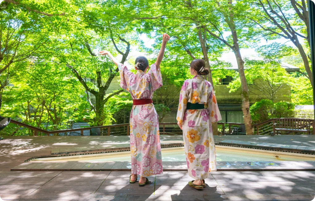 女性二人が浴衣姿で朝日を浴びる